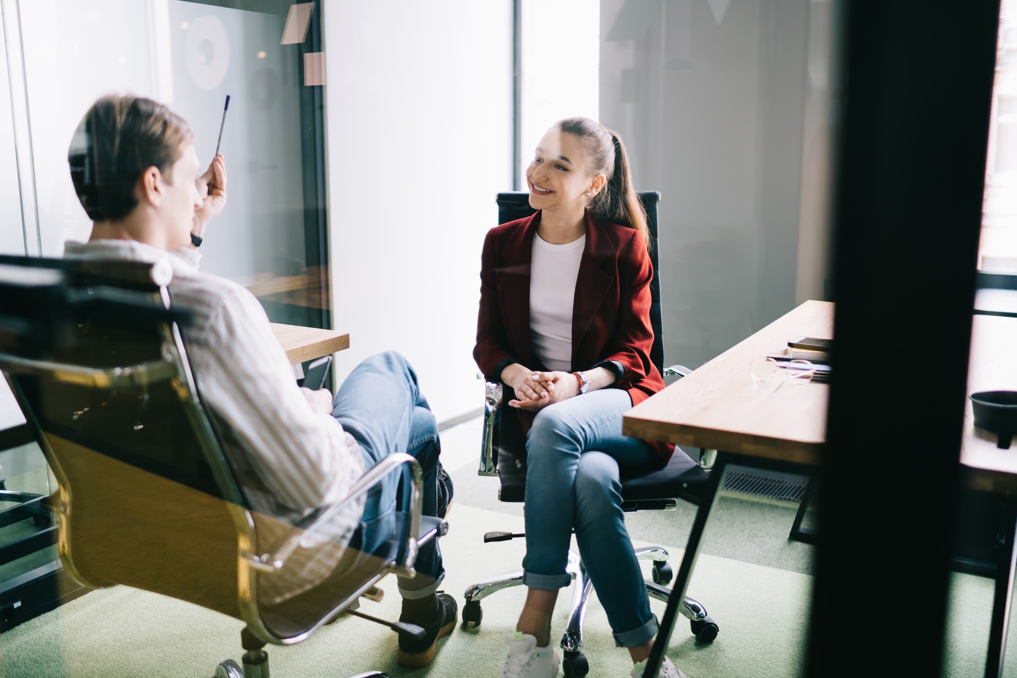 Cheerful office workers talking behind glass door