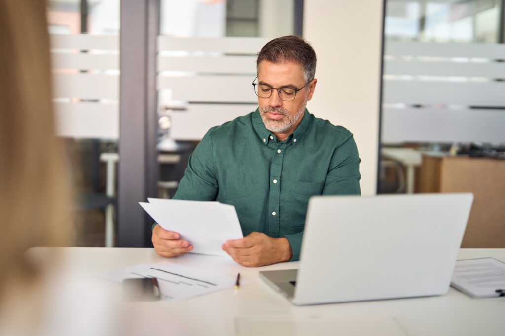 Mature business man hr manager checking cv at office meeting interview.